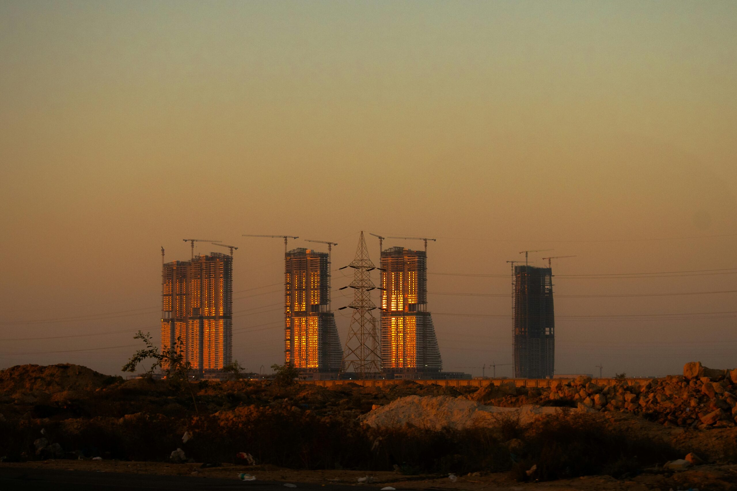 Majestic skyscrapers in El-Alamein glowing under the sunset light, showcasing modern architecture.